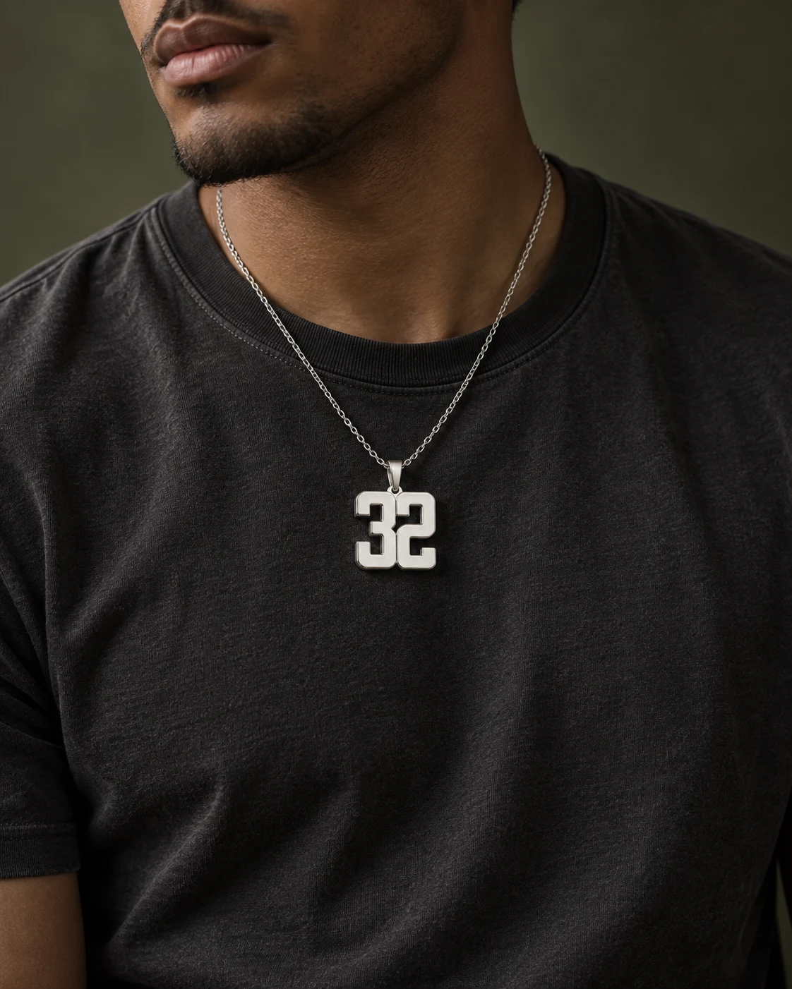 Collar de número 32 en plata sobre camiseta negra